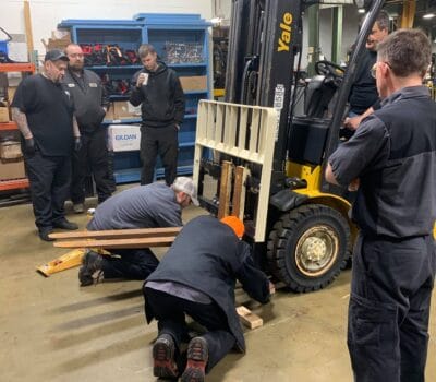 Techs lifting forklift tire training