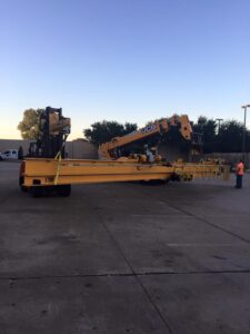 Forklifts transporting a warehouse crane.