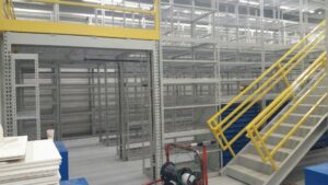 A spacious warehouse with stairs and shelves for storage.