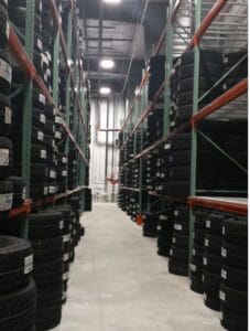 A warehouse filled with neatly stacked tires on shelves, ready for distribution and use.
