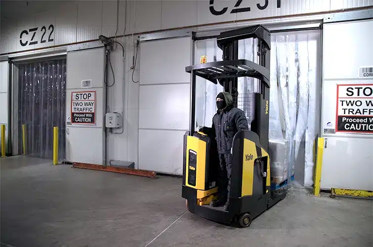Yale Reach Truck Operated by man in cold weather gear coming out of freezer