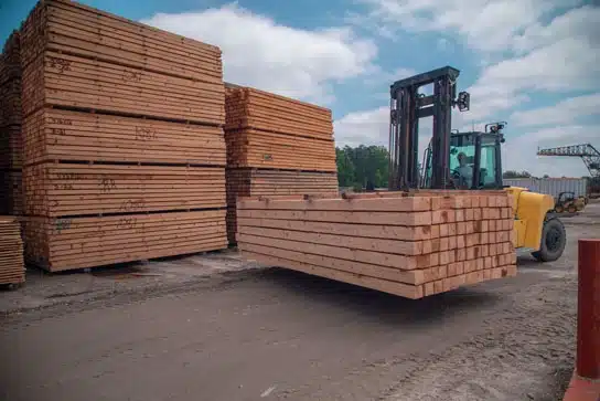 forklift moving stacks of lumber