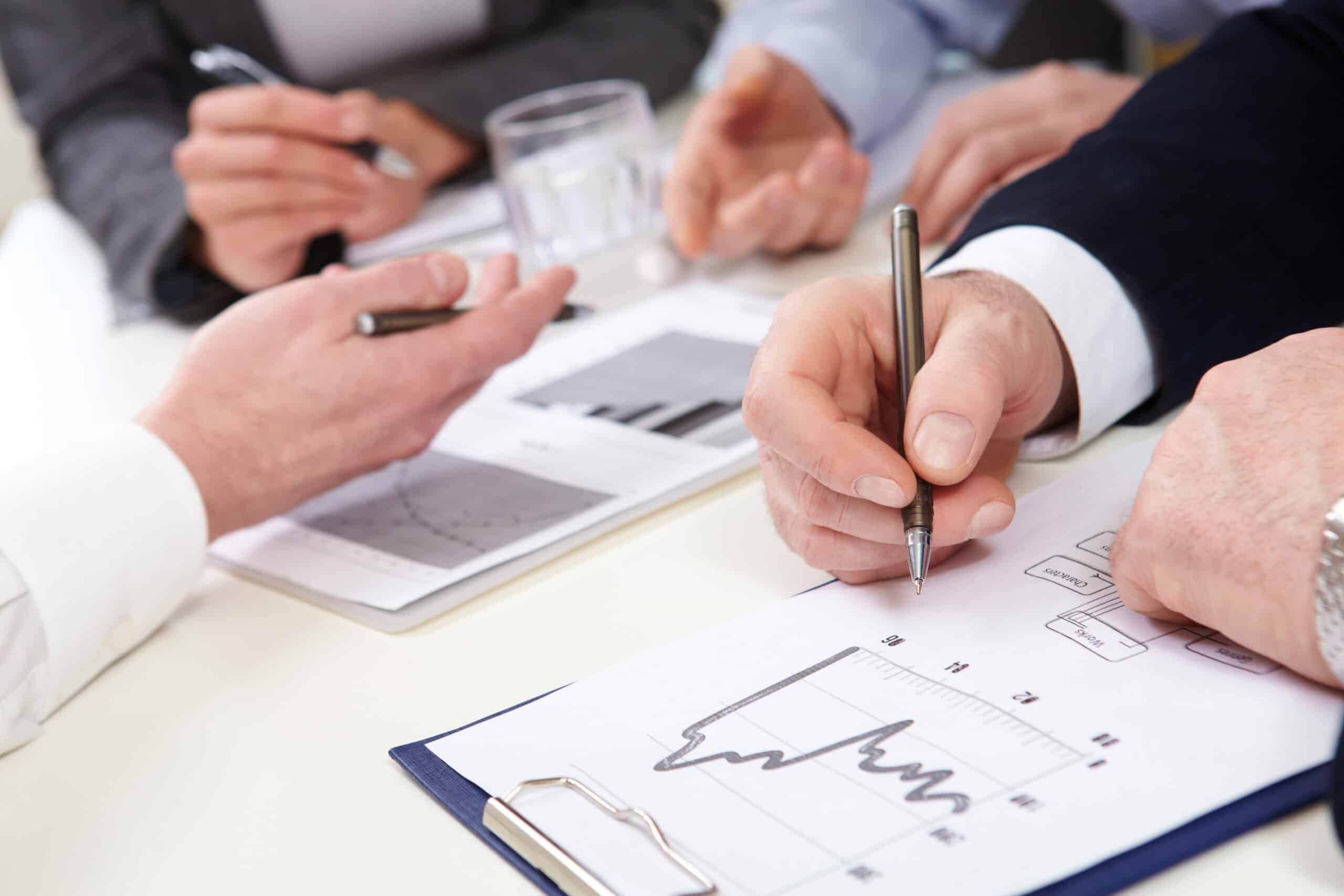 Professionals engaged in a detailed business analysis with charts and graphs during a collaborative meeting.