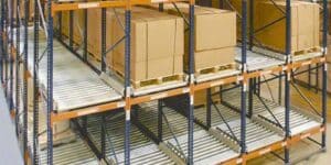 Five rows of orange racking double stacked that have rollers on the bottom and three of the top rows have pallets of boxes being stored.
