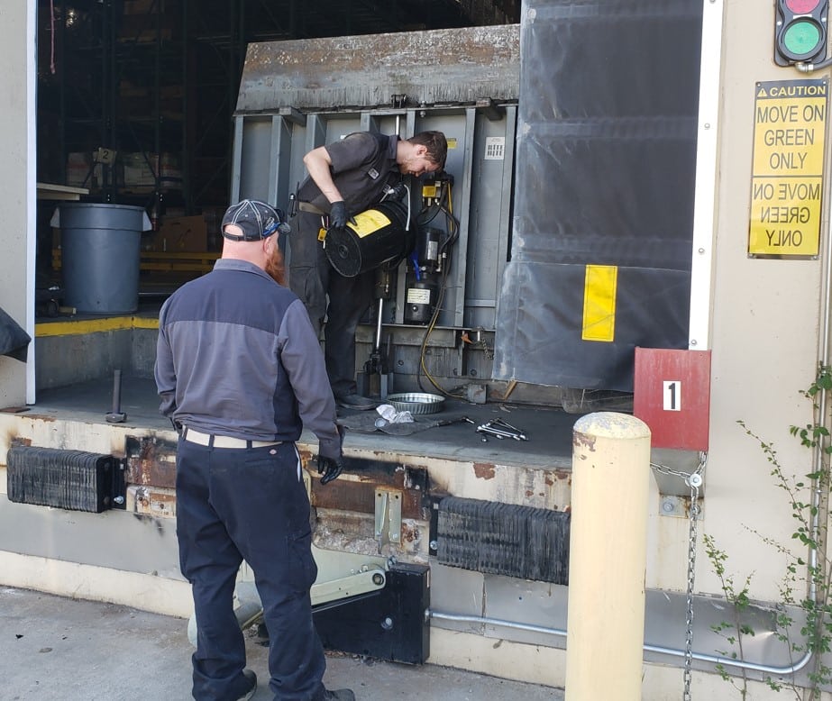 Two men in tech uniforms working on a dock