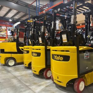 four Yale forklifts lines up in a warehouse