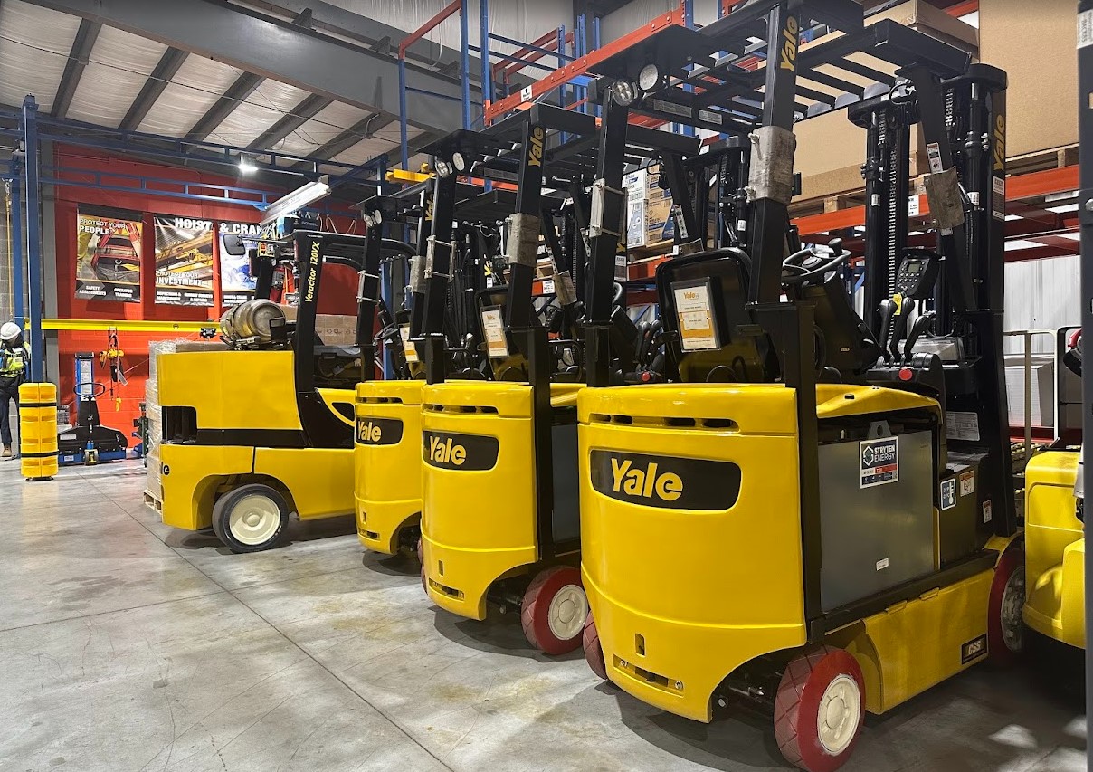 four Yale forklifts lines up in a warehouse