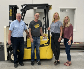 Riekes Employee with three people from Safety Council in front of a forklift used for training.
