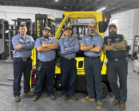 Five service technicians standing by a Hyster forklift